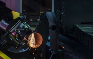 激光切割机正在对金属板材进行加工，火花四溅，展示工业生产的力量感