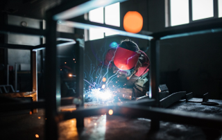 专业钣金焊接车间场景，工程师正在操作焊接设备，火花四溅，展现hit焊接工艺的工业化应用