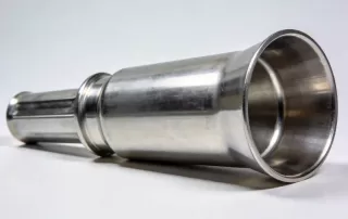 横屏展示的金属杯形零件，表面光滑呈现金属光泽，深拉伸工艺成品的精密质量