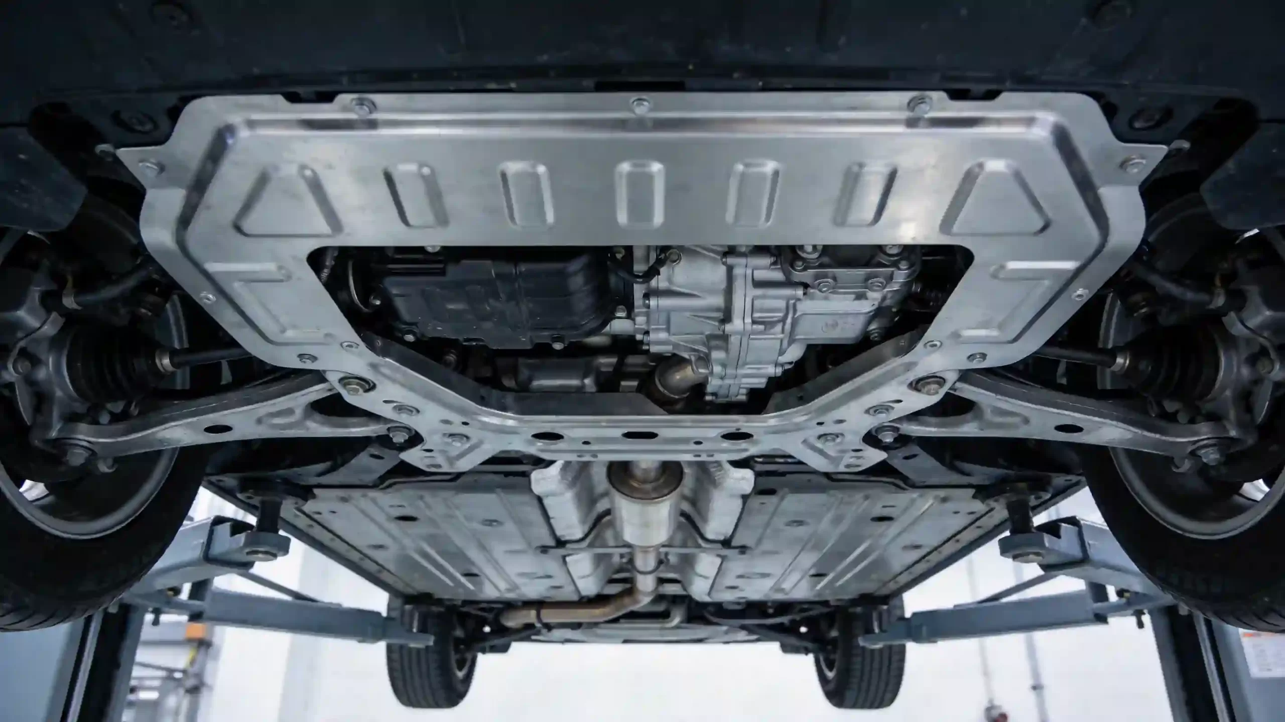 汽车底盘护板安装在车辆底盘上的实景展示图，展示护板对发动机、变速箱等关键部件的防护效果，安装孔位精准匹配